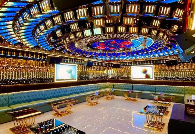 Phòng hát Karaoke Tiptop với trần gương ánh xanh, ghế sofa xanh ngọc bọc nút, bàn mạ vàng và hai màn hình