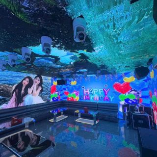 Phòng hát S KTV Club phủ màn hình LED quanh tường và trần, hiển thị dòng chữ Happy Birthday, sofa dài