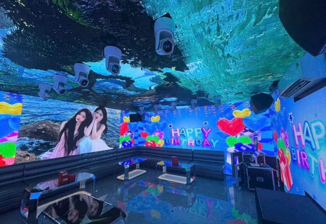 Phòng hát S KTV Club phủ màn hình LED quanh tường và trần, hiển thị dòng chữ Happy Birthday, sofa dài