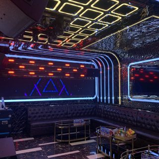 Phòng hát tông tối ở Karaoke Level, trần đèn LED vuông, sofa da đen, xe đẩy đồ uống mạ vàng