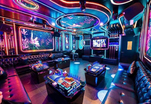 Phòng hát VIP tại Karaoke S KTV Club với sofa da đen, bàn kính bày trái cây và đèn LED nhiều màu
