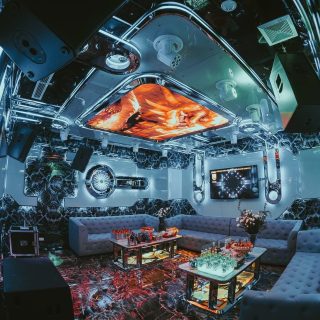 Phòng hát Karaoke Thượng Hải KTV với trần LED hình thoi, tường inox gương, sofa xám và bàn kính bày đồ uống