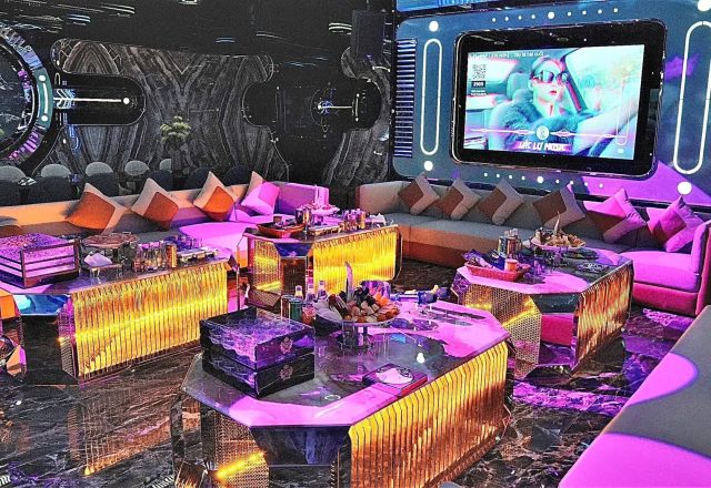 Phòng hát tại Karaoke Thượng Hải KTV 229 Tây Sơn dưới ánh đèn tím hồng, sofa gối tựa, bàn phát sáng và màn hình lớn