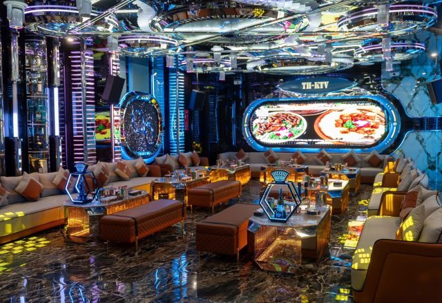 Phòng hát rộng tại Karaoke Thượng Hải KTV 229 Tây Sơn với nhiều dãy sofa, bàn ánh vàng, màn hình LED và trần đèn tròn